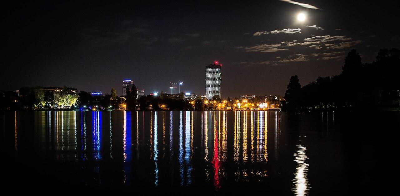 SkyTower and Bucharest skyline seen from Herăstrău Park at night